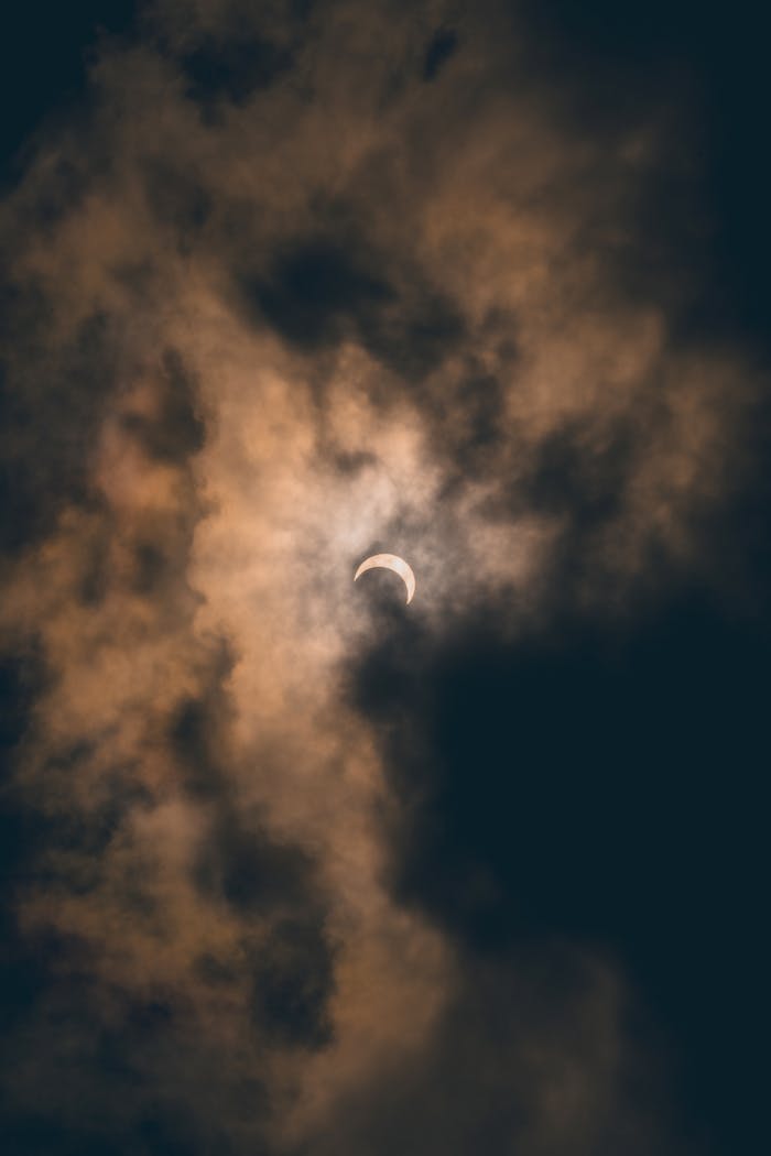 A dramatic view of a lunar eclipse shrouded by dark, eerie clouds in Akumal, Mexico.